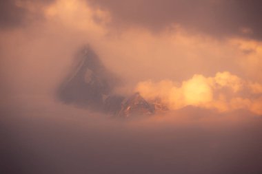 Güney Annapurna 'nın nefes kesici sabah manzarası. Nepal' deki büyük Himalayalar 'da bulutlar ve güneş ışığı altında yüzerken..