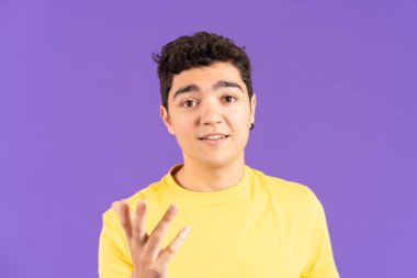 Hispanic teenager boy talking to camera or live streaming isolated on purple background