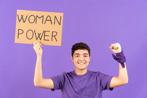 Feminist activist teenager boy raising billboard with woman power message isolated on purple background