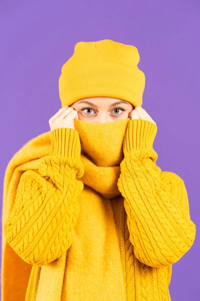 冬服認識できない女性は 紫色の背景に孤立したカメラを見ながらスカーフで顔を覆う — ストック写真