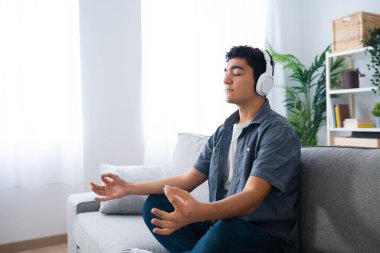 İspanyol genç çocuk evde meditasyon yaparken dinleniyor.