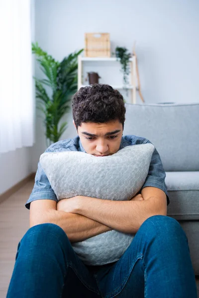 Yastığı kucaklayan üzgün, düşünceli İspanyol genç çocuk. Depresyon ve akıl sağlığı kavramı