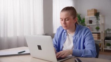 Pretty woman working from home on laptop and receiving bad news on laptop.