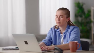 Freelancer working on laptop at home. Pretty woman with stress overworking and resting head on desk