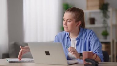 Pretty woman having video call on laptop. Teacher working from home and talking on an online class.