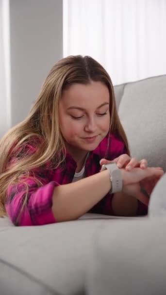 Young Beautiful Woman Talking Smart Watch While Lying Sofa Wireless — Stockvideo