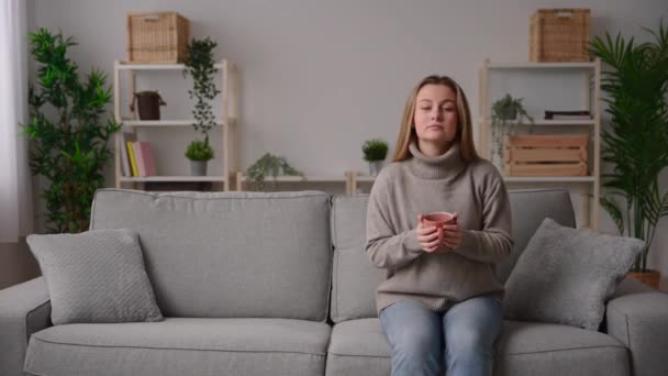 Mladá Žena Relaxuje Pohovce Šálkem Kávy Nebo Čaje — Stock video