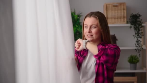 Mujer Joven Hablando Smartwatch Mientras Mira Por Ventana — Vídeo de stock