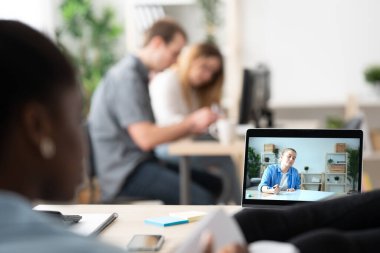 Siyahi bir kadın, ofisteki bilgisayar ekranından özel ders izliyor..