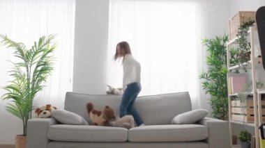 Çocuk evdeki kanepeye yumuşak oyuncaklar fırlatıp zıplıyor. Hiperaktivite kavramı