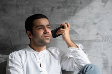 İspanyol genç adam telefonda sesli mesaj dinliyor..