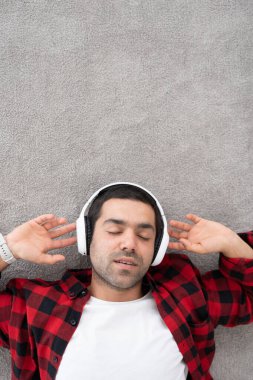 İspanyol genç adam, halının üzerinde, fotokopi aletiyle rahatlatıcı müzik dinliyor..