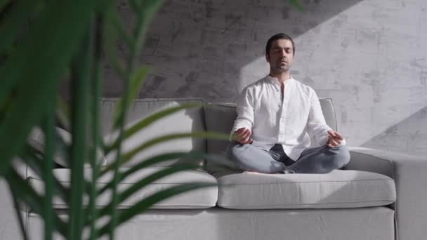 Іспанський Молодий Чоловік Медитує Сидячи Дивані Приміщенні Релаксація Дихальні Вправи — стокове відео