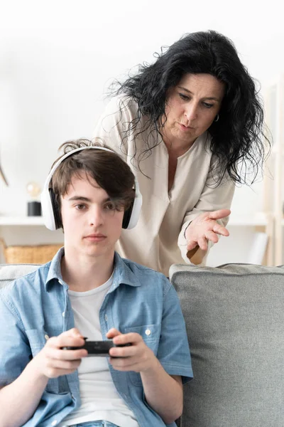 stock image Mother scolding and trying to talk to teenager son while he is playing video games. Gaming addiction concept