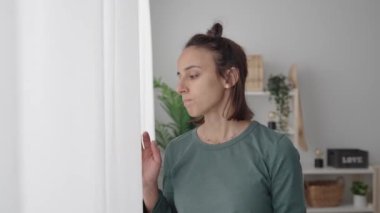 Pencereden bakan üzgün, düşünceli İspanyol genç kadın. Depresyon ve akıl sağlığı kavramı.