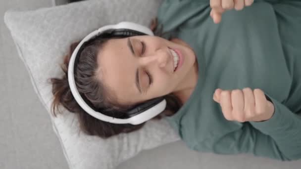 Ovanifrån Latinamerikansk Ung Kvinna Lyssnar Musik Hörlurar Medan Liggande Soffa — Stockvideo