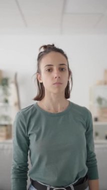 İspanyol genç kadın kameraya bakarken el hareketi yapmayı kesiyor.