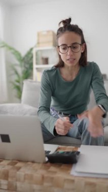 Evden çalışan Latin kökenli genç bir kadın. Bir kişinin bilgisayarında görüntülü arama var.