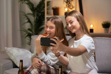 Güzel genç kadınlar gece pizza yerken selfie çekiyorlar..