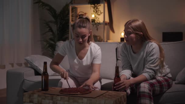 Pizsamát Viselő Fiatal Nők Pizzát Esznek Beszélgetnek — Stock videók