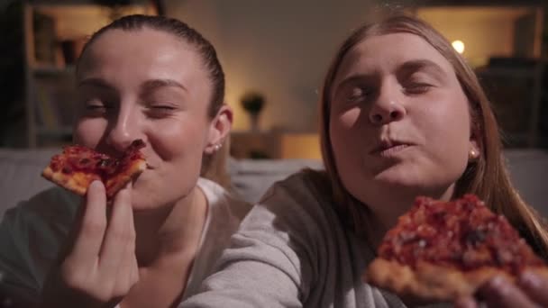 2人の女性の閉鎖の夜にピザを食べている 不健康な食べ物を貪る友人 — ストック動画