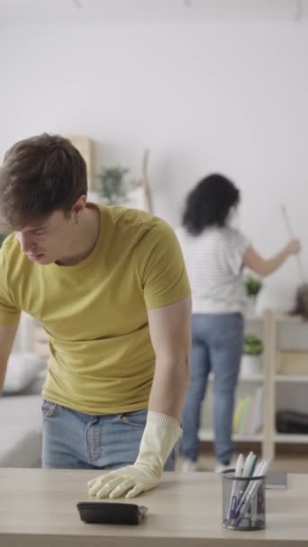 １０代の男の子が家で机を掃除している 家事を一緒にする家族 平等の概念 — ストック動画