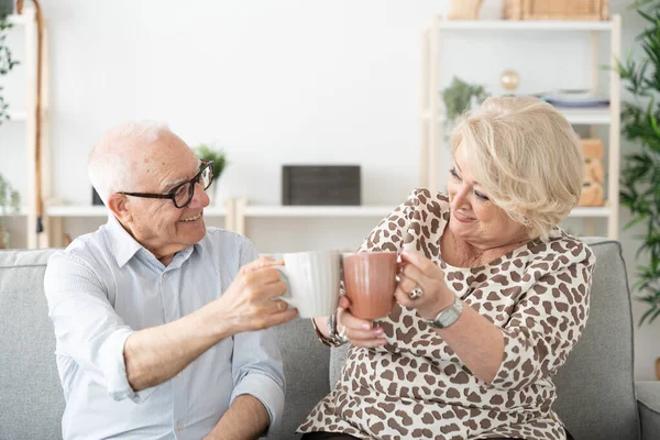 Ancianos Pareja Positiva Compartiendo Taza Café Sentado Sofá — Foto de Stock