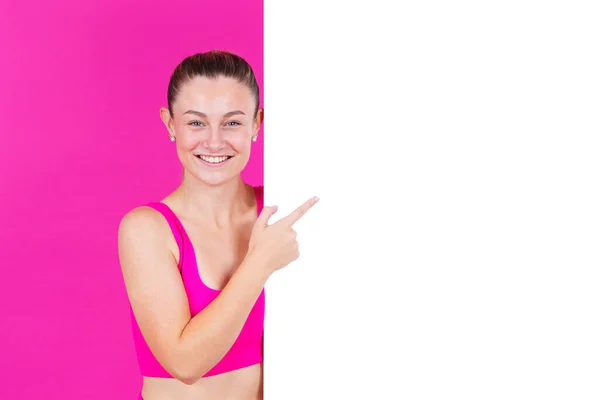 Pozytywna Sportowiec Pokazuje Biały Sztandar Młoda Kobieta Wskazując Przestrzeń Kopiowania — Zdjęcie stockowe