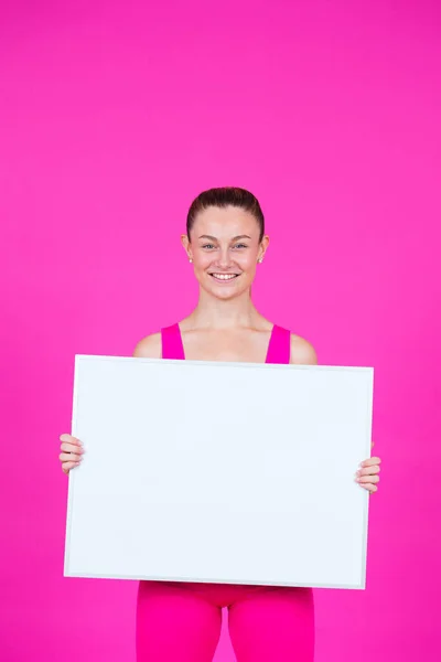 Mladá Sportovkyně Drží Bílý Billboard Izolované Růžovém Pozadí — Stock fotografie