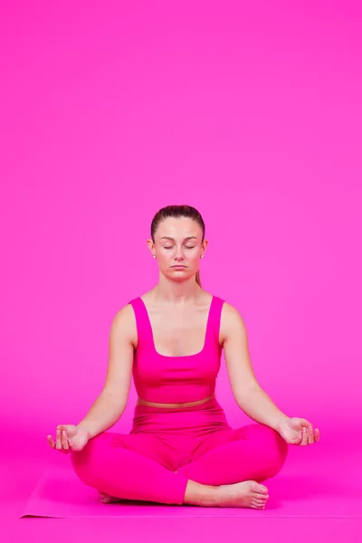Pembe Arka Planda Meditasyon Yapan Genç Güzel Bir Kadın — Stok fotoğraf