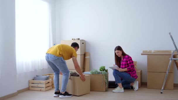 Mladý Pár Stěhuje Domů Přepravuje Krabice Muž Mluví Přítelkyní Výzdobě — Stock video