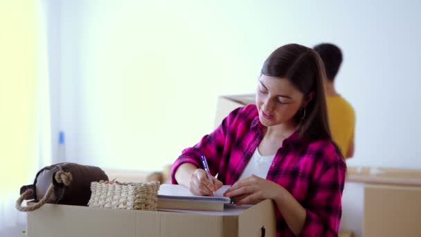 Junge Frau Schreibt Checkliste Mit Freund Ihrem Neuen Haus Konzept — Stockvideo
