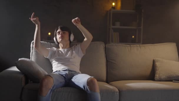 Teenager Αγόρι Ακούγοντας Χαλαρωτική Μουσική Κάθεται Στον Καναπέ Βράδυ — Αρχείο Βίντεο