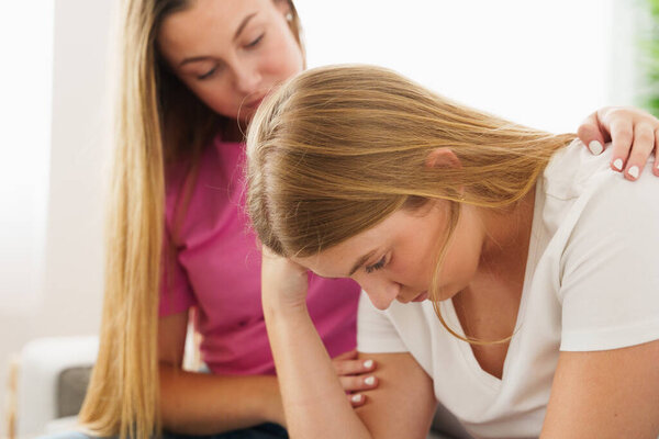 Young woman consoling sad friend. Depression and mourning concept