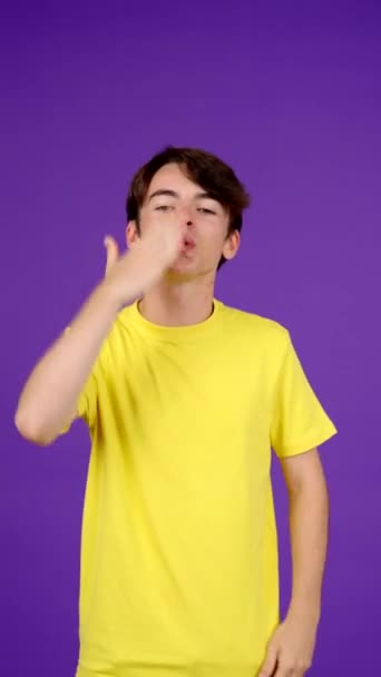 Nastolatek Chłopiec Wysyłanie Pocałunek Miłość Patrząc Aparat Odizolowany Fioletowy Tło — Wideo stockowe