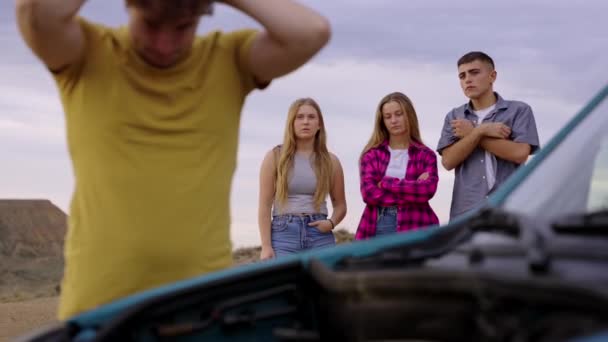 Unge Man Reparerar Bilen Framför Vänner Turister Grupp Ringer Försäkringsbolag — Stockvideo