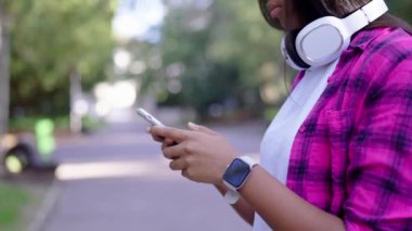 Açık havada telefon kullanan tanınmayan siyahi kadın. Afrikalı Amerikalı genç sohbet ediyor.