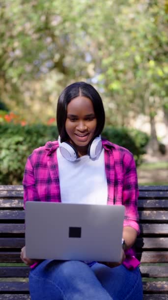 アフリカ系アメリカ人女性が公園でラップトップでビデオ通話をする — ストック動画