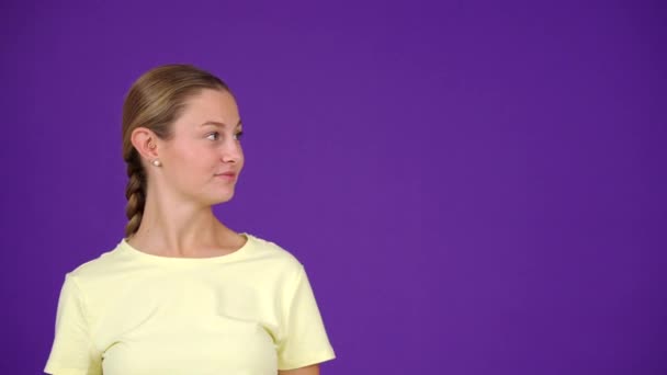 Junge Überraschte Frau Zeigt Auf Kopierraum Isoliert Auf Lila Hintergrund — Stockvideo