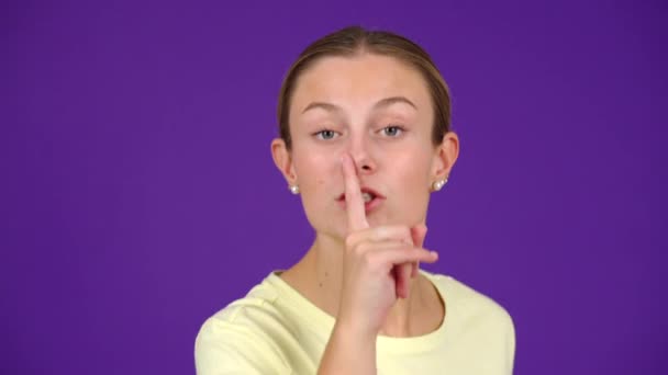 Ernstige Jonge Vrouw Vraagt Stilte Vinger Lippen Geïsoleerd Paarse Achtergrond — Stockvideo