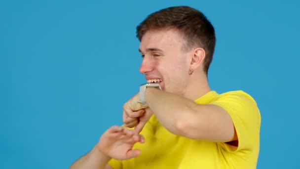 Positiv Ung Man Talar Smart Klocka Isolerad Blå Bakgrund — Stockvideo