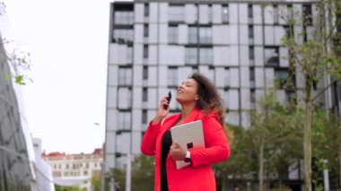 Siyah kıvrımlı iş kadını dışarıda yürüyor. Afro-Amerikalı kendine güvenen kadın telefonda konuşuyor. Güçlendirme kavramı