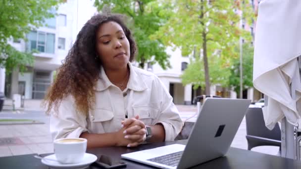 年轻的黑人妇女在酒吧的阳台上举行视频会议 在室外用笔记本电脑交谈的非裔美国人 — 图库视频影像