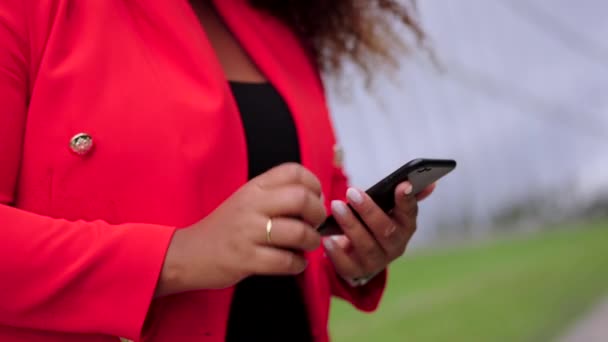 外で携帯電話を使っている女性 テキストメッセージを送信する手のクローズアップ — ストック動画