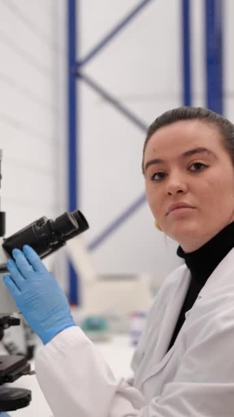 Mujer Científica Joven Usando Microscopio Luego Mirando Cámara — Vídeos de Stock