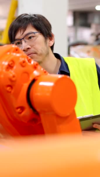 Азиатский Инженер Проверяет Роботов Фабрике Человек Делающий Контрольный Список Складе — стоковое видео