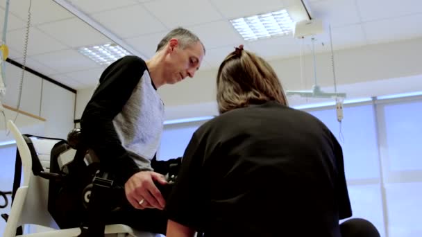 Fizjoterapeuta Przygotowujący Pacjenta Stosowania Egzoszkieletu Leczeniu — Wideo stockowe