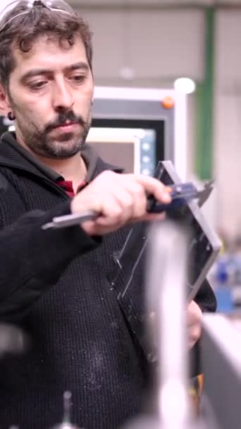 現代のCnc工場でキャリパーを使用して金属片を測定するエンジニアのビデオ — ストック動画