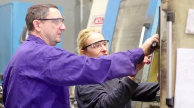 Modern endüstriyel üretim bandındaki bir kontrol odasındaki bir grup işçinin videosu.