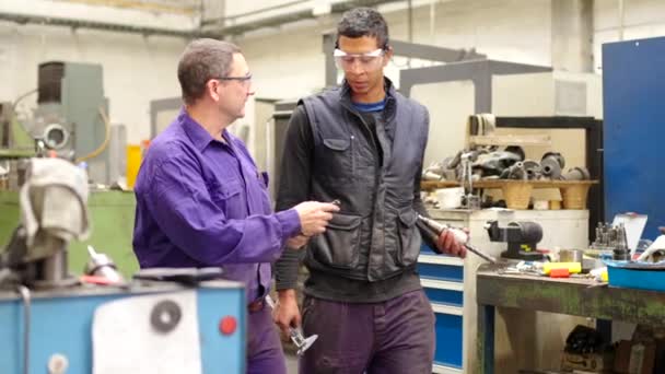 話しながらCnc工場で旋盤を運ぶ2人のエンジニアのビデオ — ストック動画